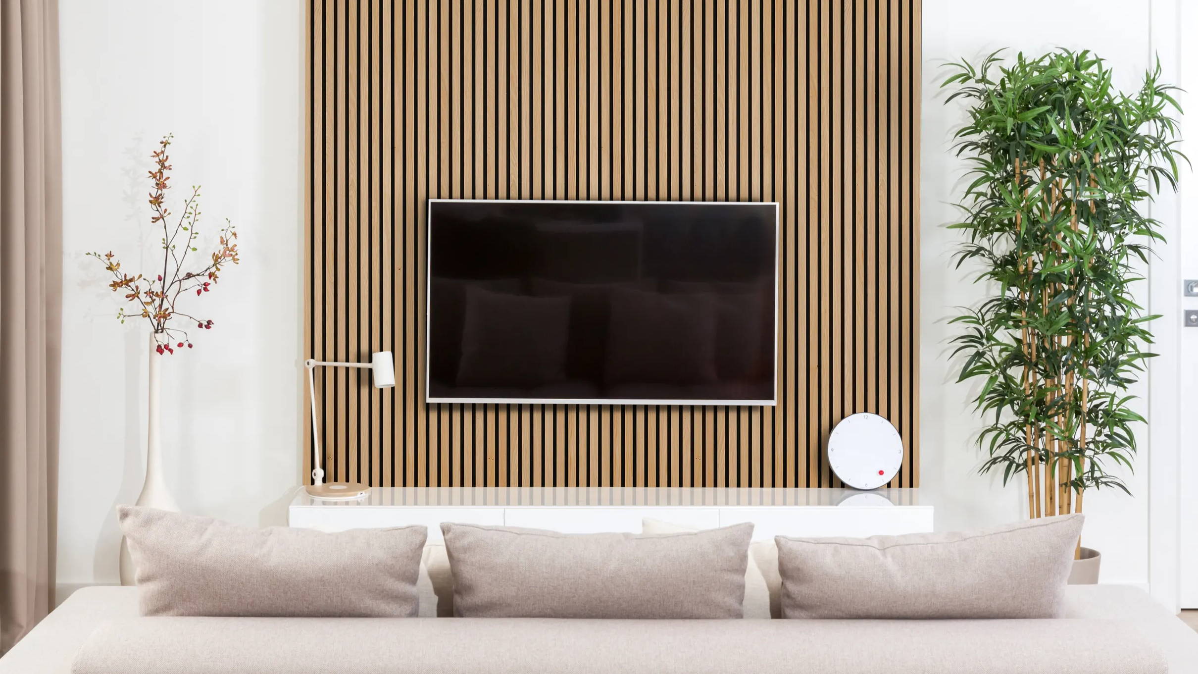 Natural oak acoustic slat wood veneer wall paneling installed in modern lounge.