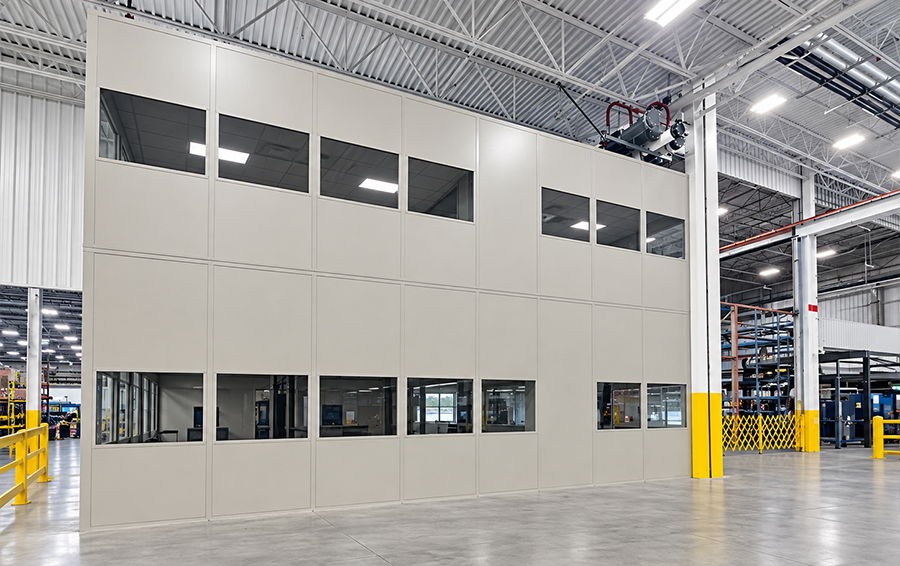 Interior of a warehouse featuring a large, beige wall with windows.