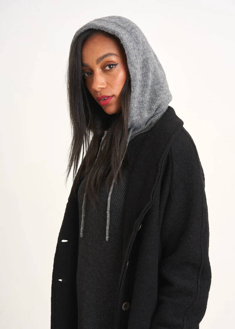 A model wearing a grey hood with a black coat
