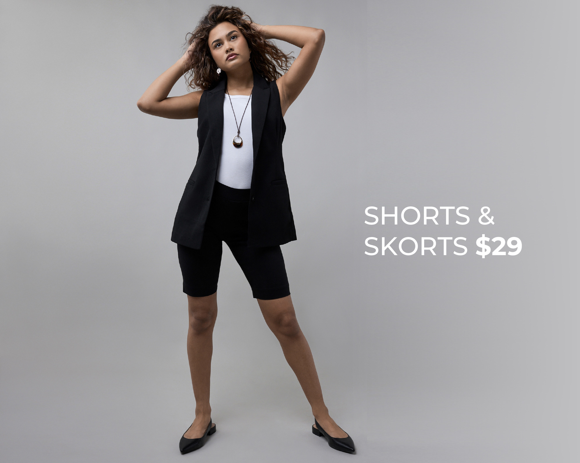 Model posing in stylish black outfit, promoting shorts and skorts for $29.
