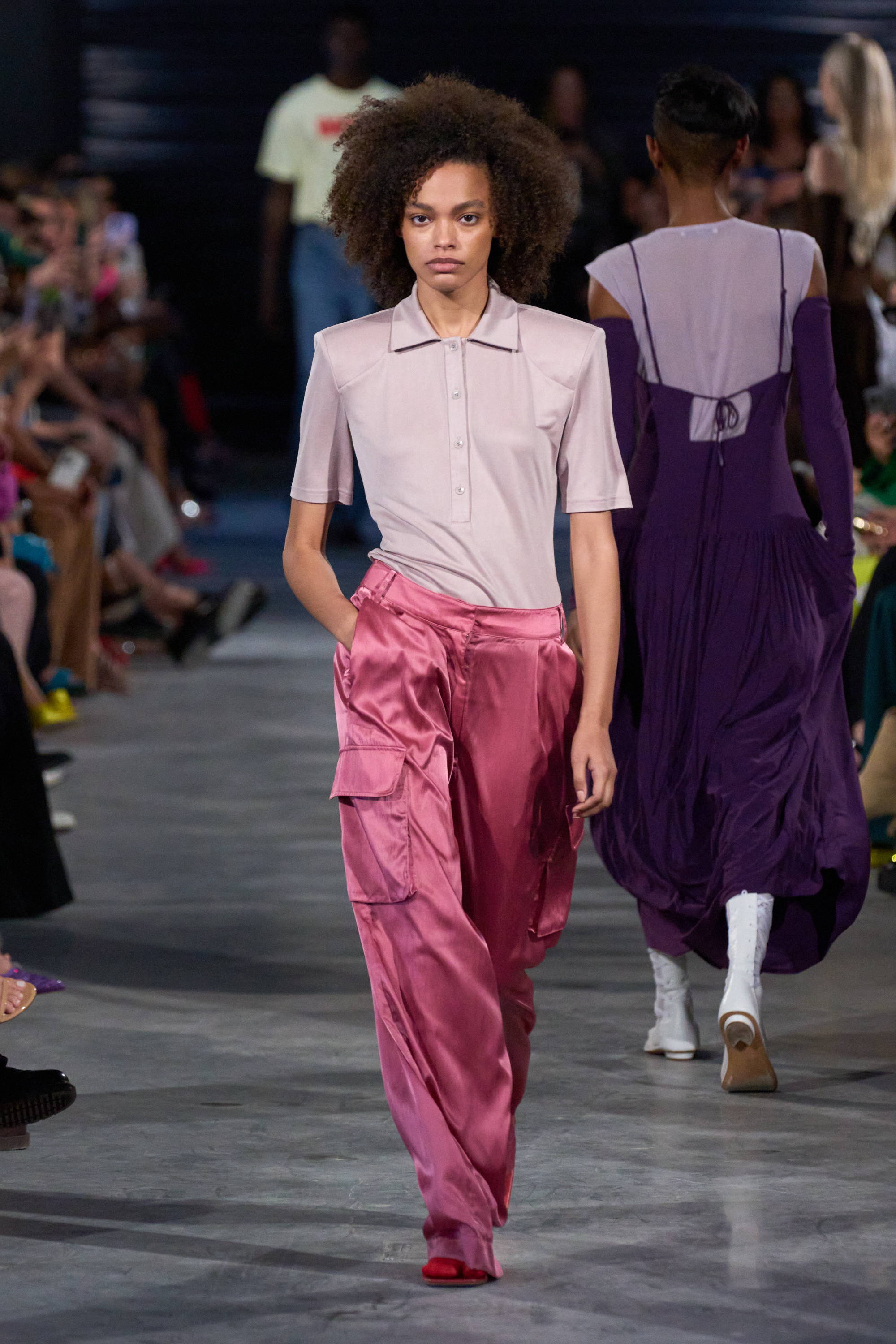 Model on a runway wearing polo and pants