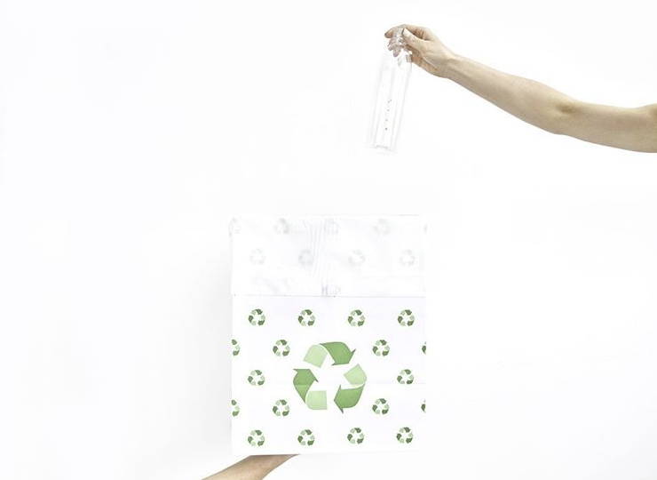 Person putting empty bottle of chlorophyll water into recycling bag