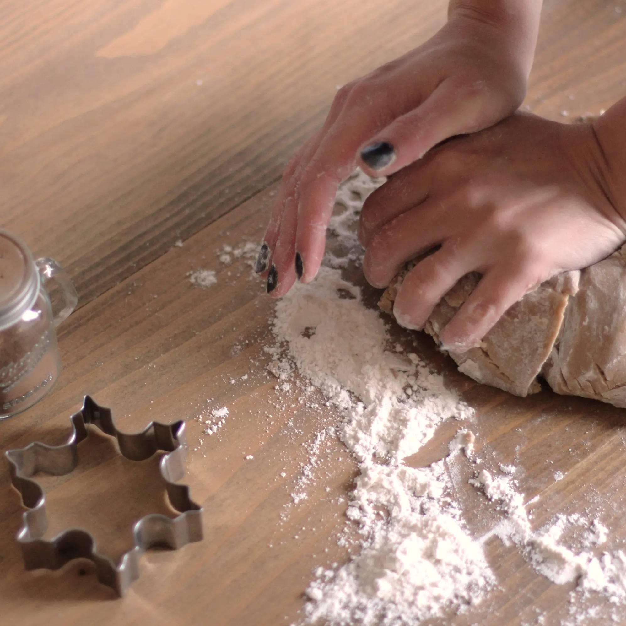 Biscuit dough being kneaded on a floured work surface