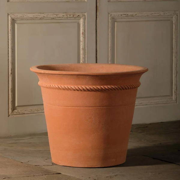 A large terracotta pot designed by Guy Wolffwith rope detailing near the top.