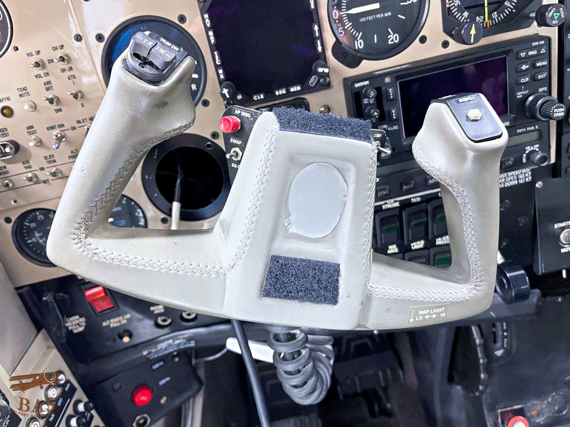 Cockpit control stick with various buttons and displays in the background.