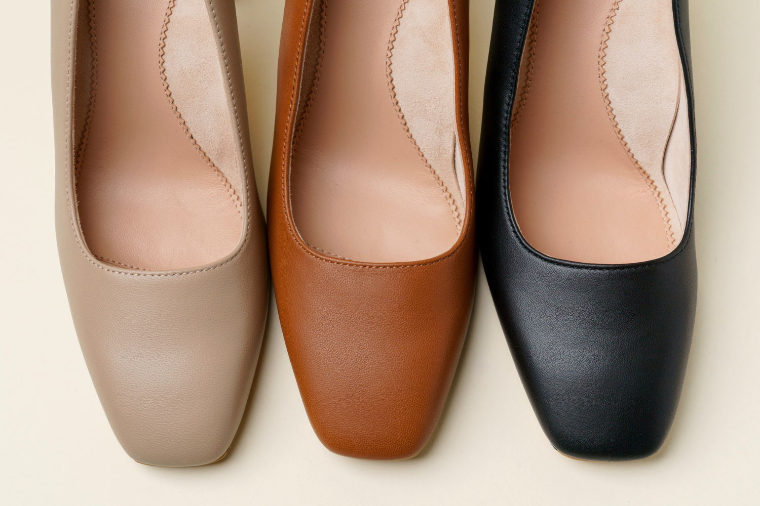 Three pairs of women's square-toed shoes in beige, brown, and black.