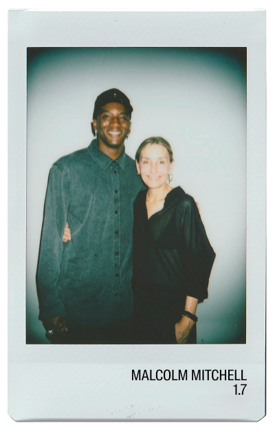Two smiling individuals posing for a photo, wearing casual attire.