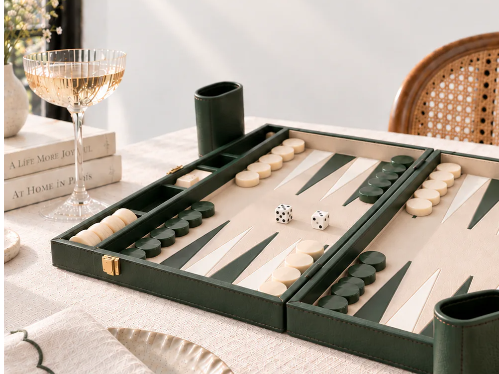 Backgammon board with game pieces, drinks, and a stylish table setting.