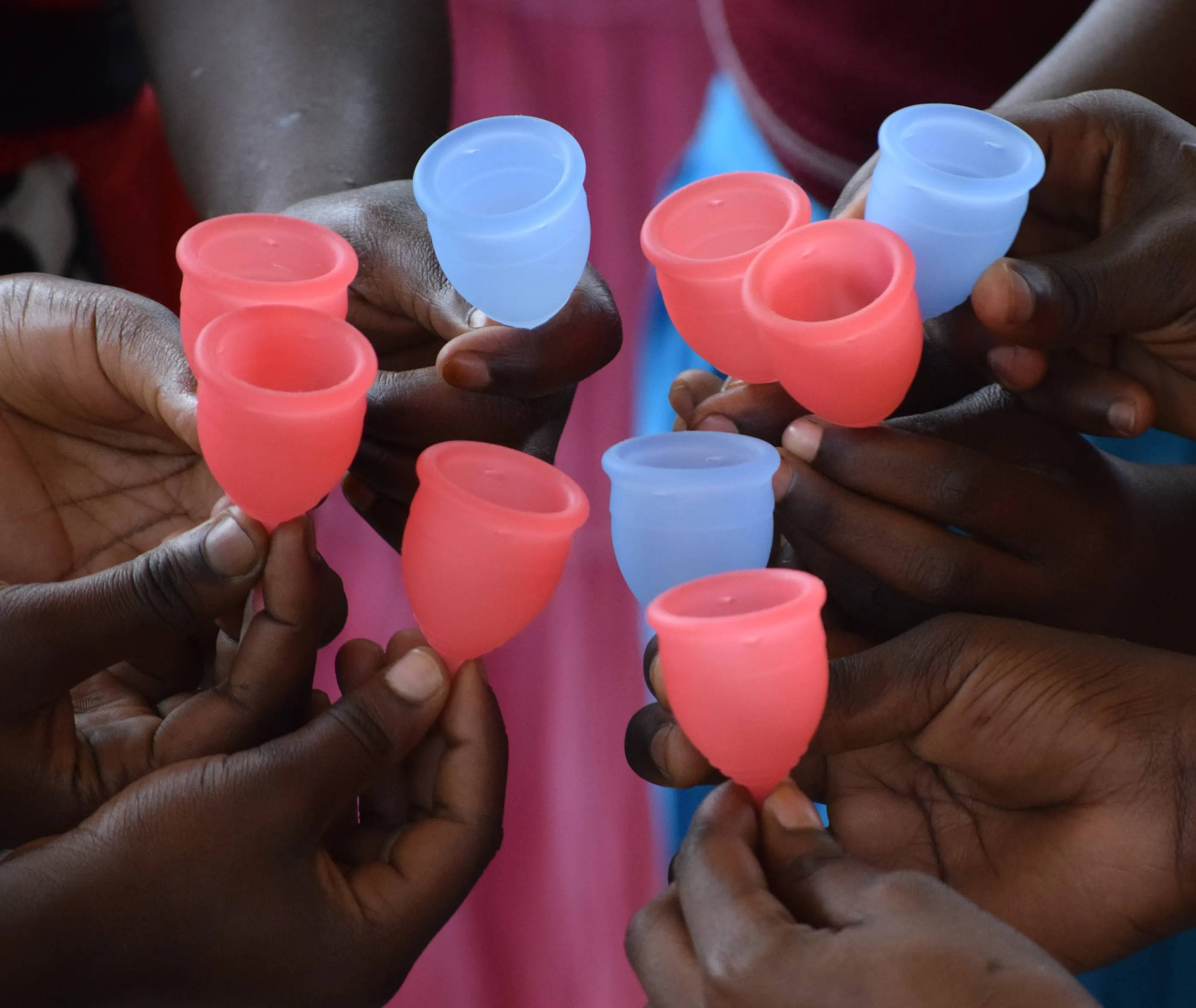 School girls in Africa holding menstrual cups.