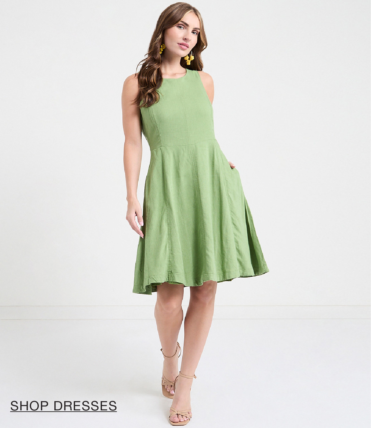 Woman in a green dress, standing and smiling.