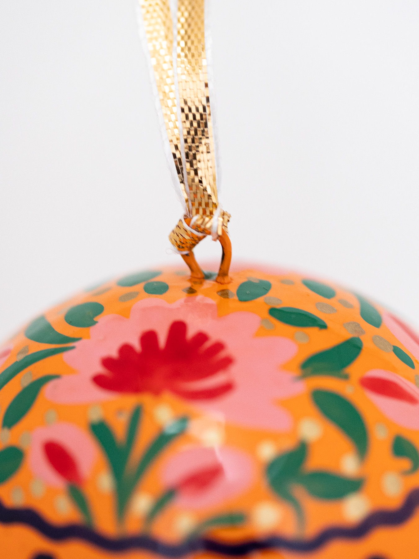Colorful ornament with floral designs and a hanging ribbon.