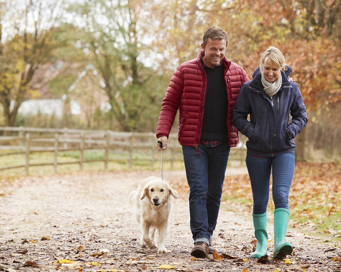 Couple walking with dog in Fall background
