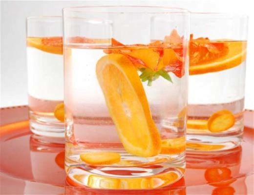 Three glasses of water with citrus slices.