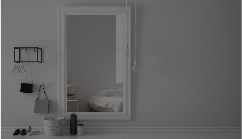 Ein Spiegel in einem Wohnzimmer auf einer grauen Wand hängend