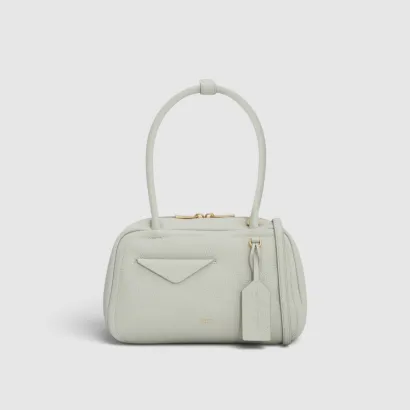 A small, light gray handbag with a top handle and tag.