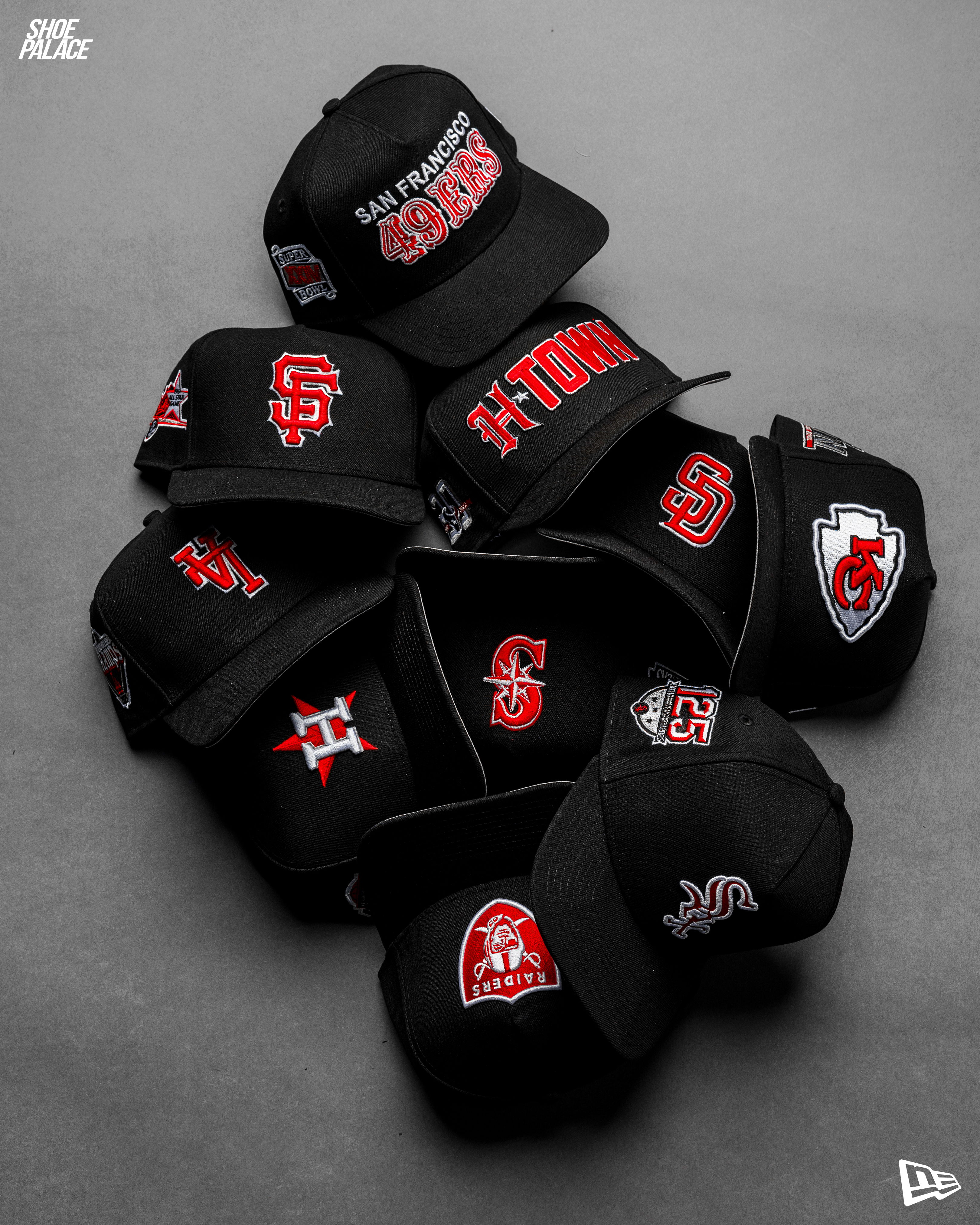 A pile of black caps with various logos and designs on them.