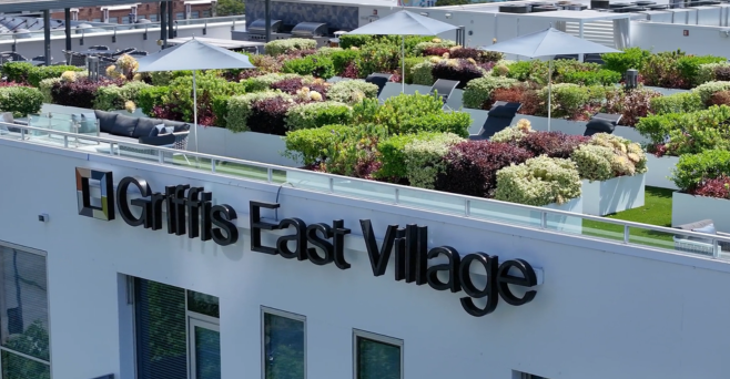 Sign for Griffis East Village with green rooftop garden.