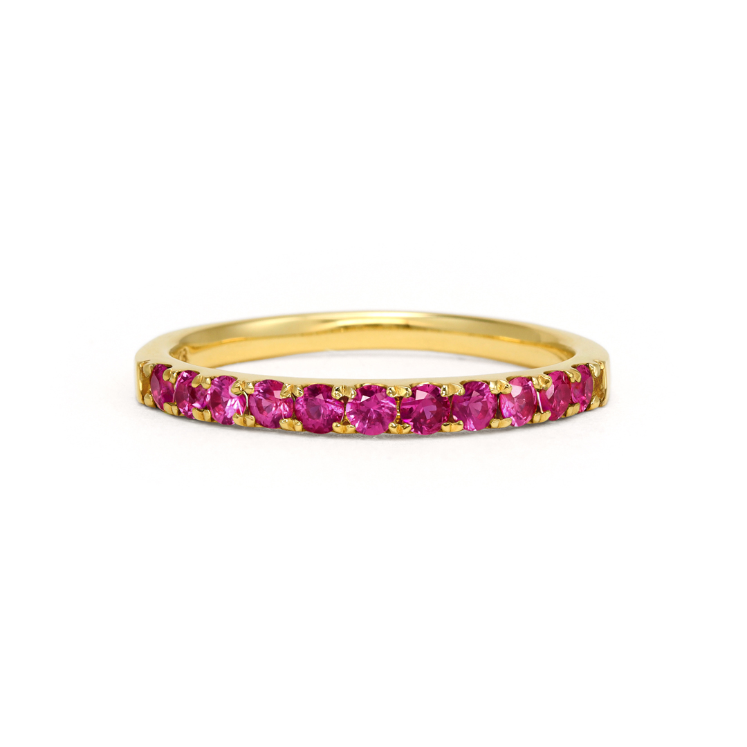 Gold ring with pink gemstones set around the band.