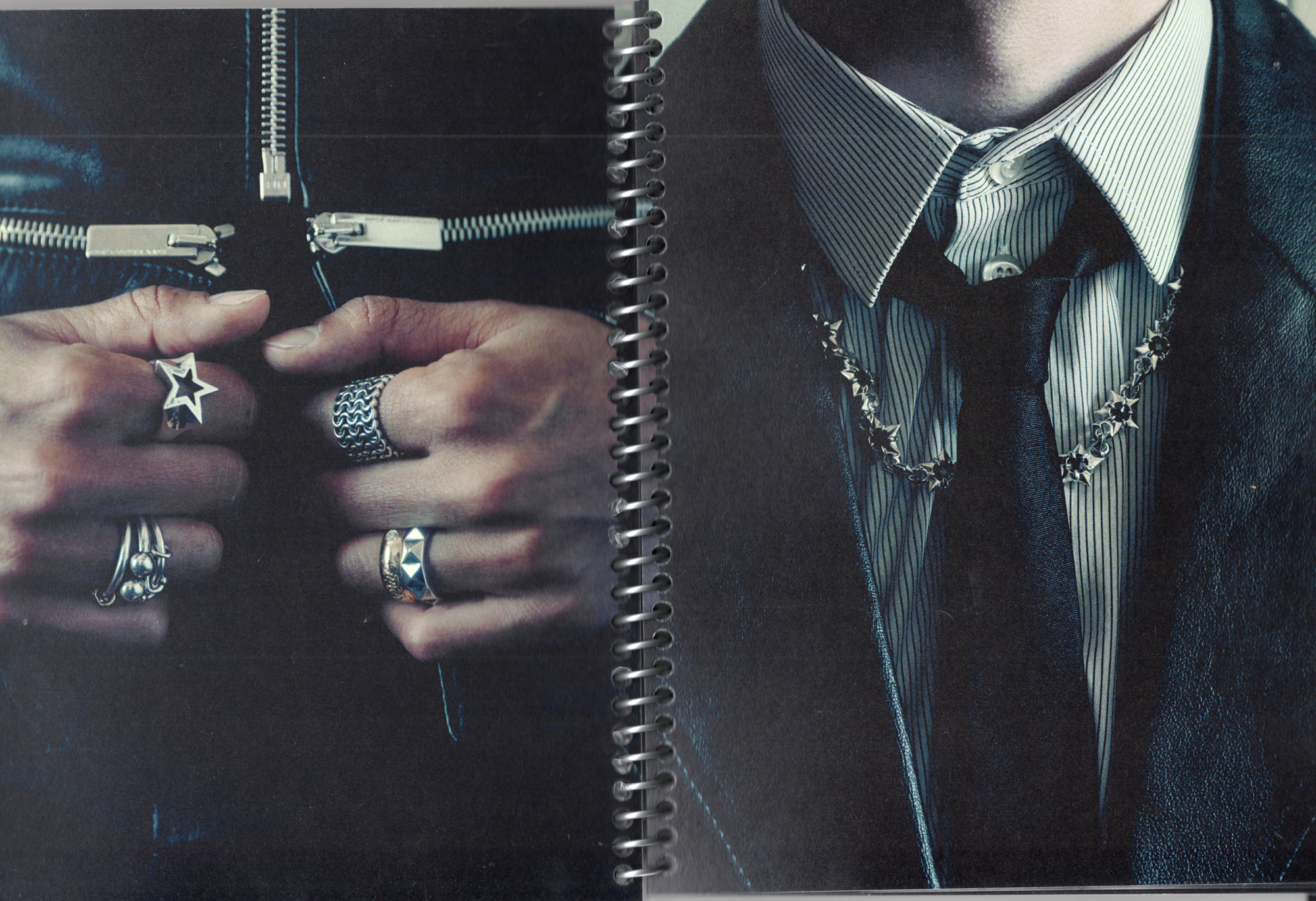 Hands adorned with rings, holding a cross, next to a suited torso.