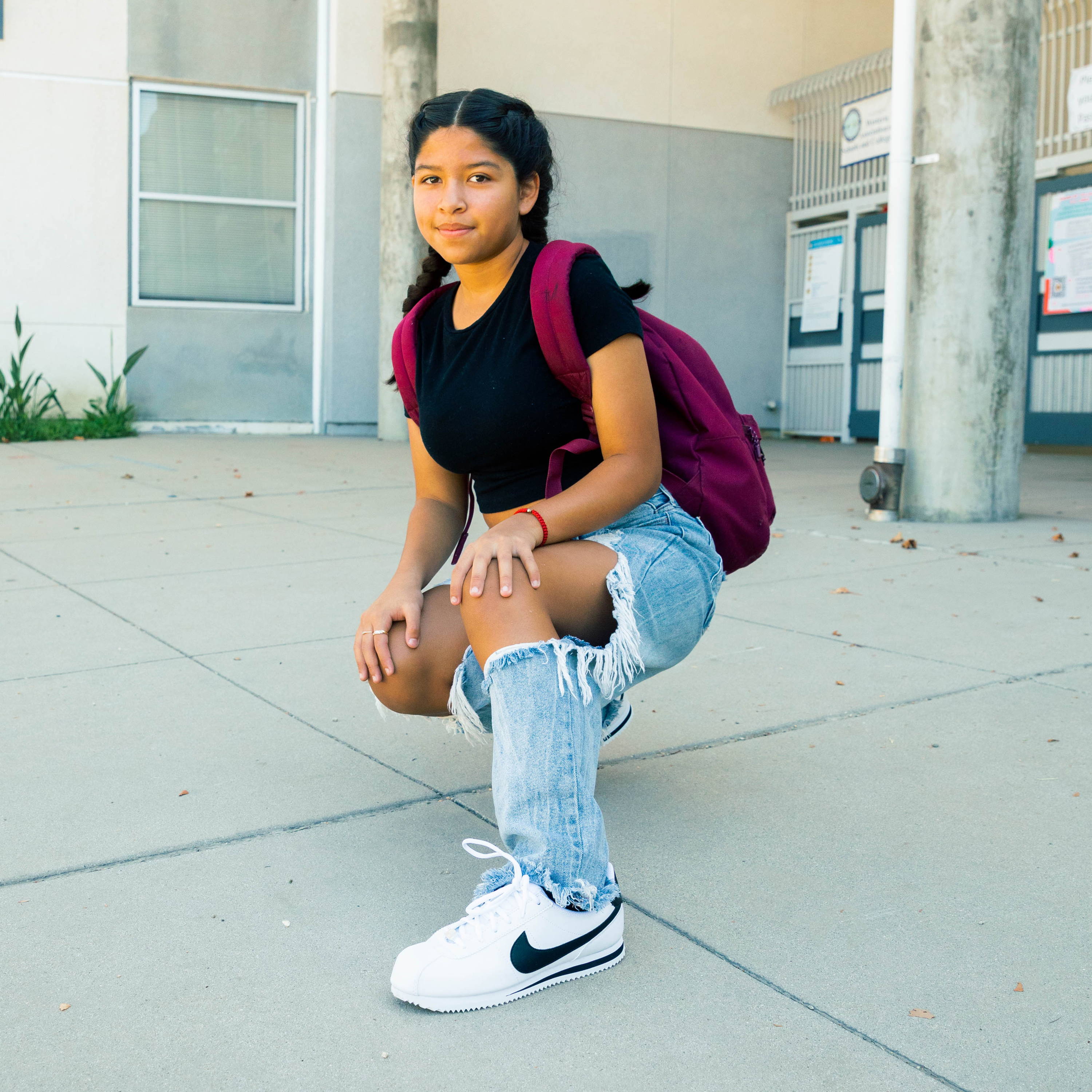 young girl at school wearing nike cortez shoes