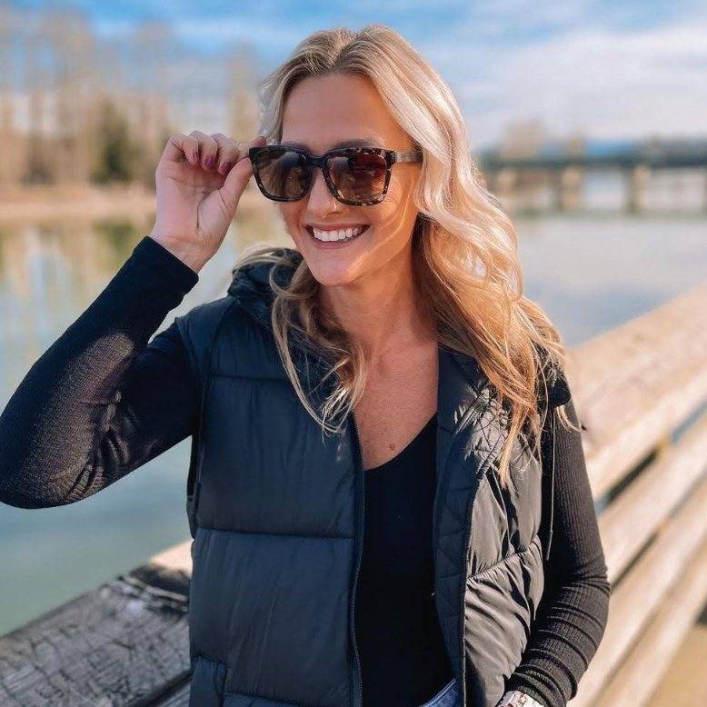 Woman wearing floating wood sunglasses styled over jacket