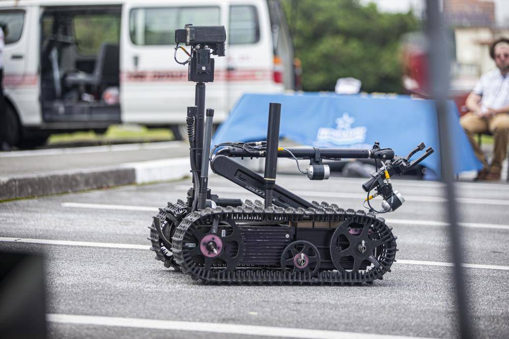 A Foster-Miller TALON robot is operated by families during the Headquarters and Support Battalion Family Day event on Camp Foster, Okinawa, Japan, on April 22, 2022. Family Day allowed service members to engage in activities with their children, allowing them to view military vehicles, participate in a mock combat fitness test, and learn professional training from the Marine Corps Martial Arts Program and the Marksmanship Training Unit. (U.S. Marine Corps photo by Cpl. Alex Fairchild)