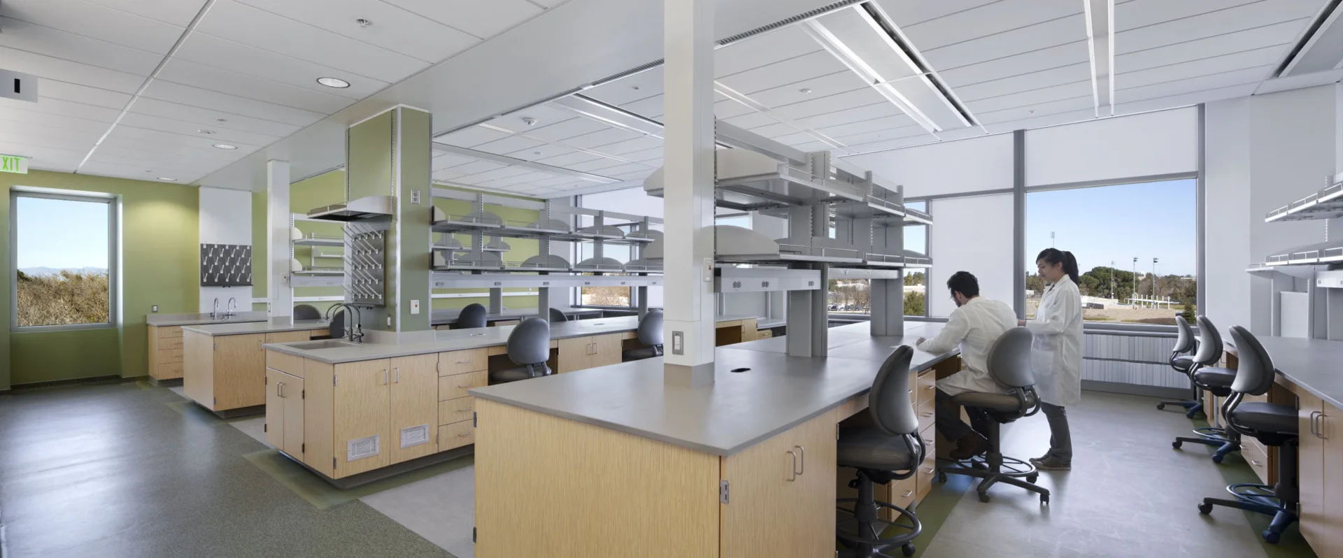 Modern laboratory interior with workstations and large windows.