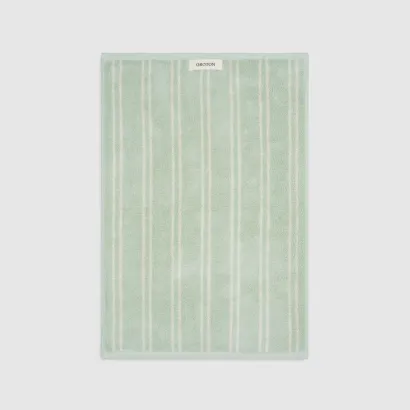 Light green striped towel on a gray background.