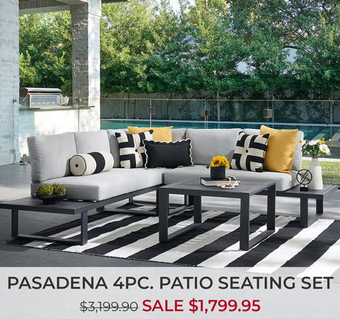 Patio seating set with cushions and a coffee table on a striped rug.