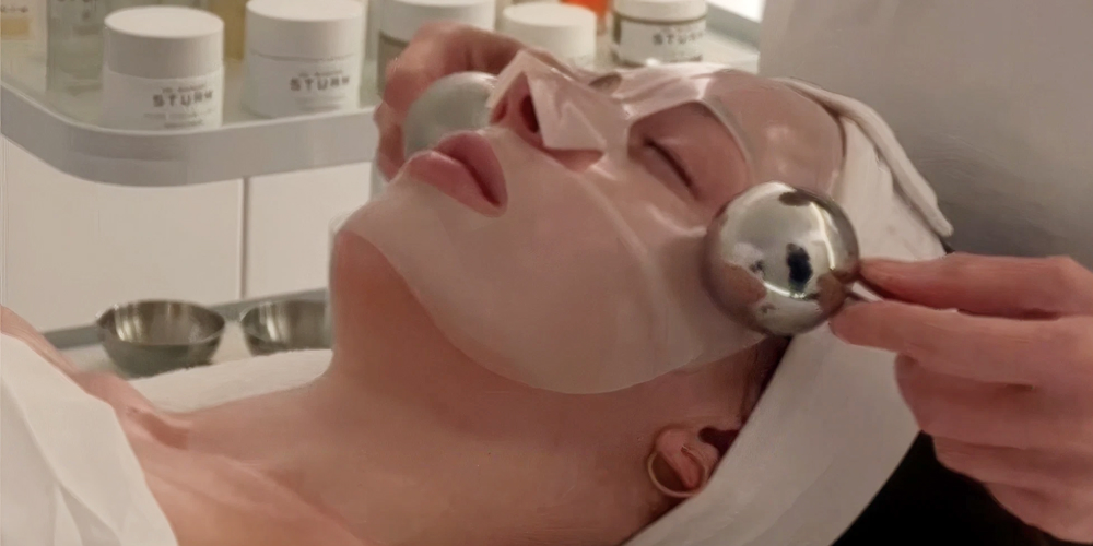 Person receiving a facial treatment with tools applied to their face.