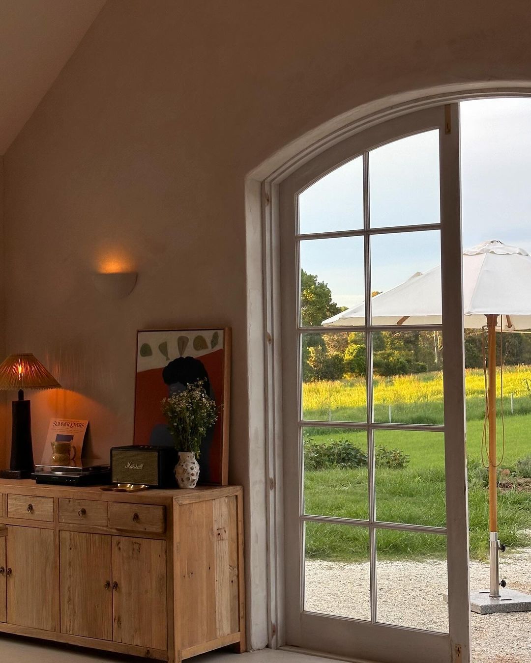 La Jardin french rustic living room with outdoor view and plaster wall light