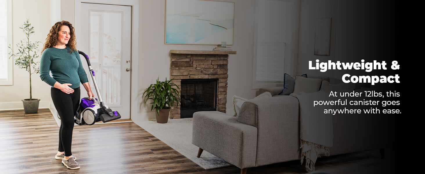 A woman demonstrating a lightweight vacuum cleaner in a modern living room.