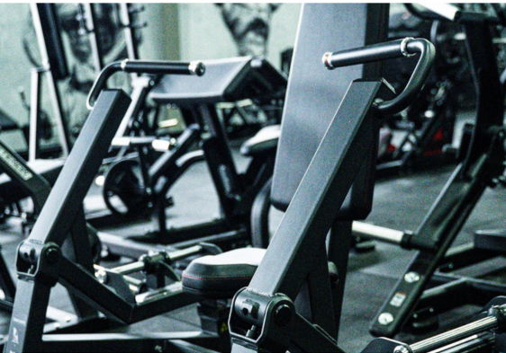 Gym equipment in a fitness center with various machines.