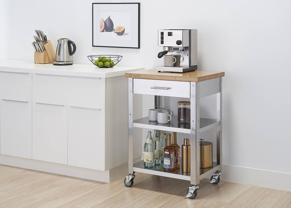 Stainless steel kitchen cart in a kitchen with a coffee maker sitting on top of the bamboo top