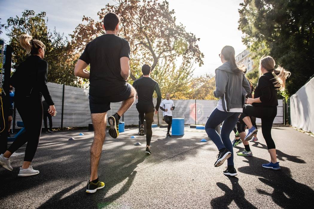 Group Of People Exercising Outside In The Sun