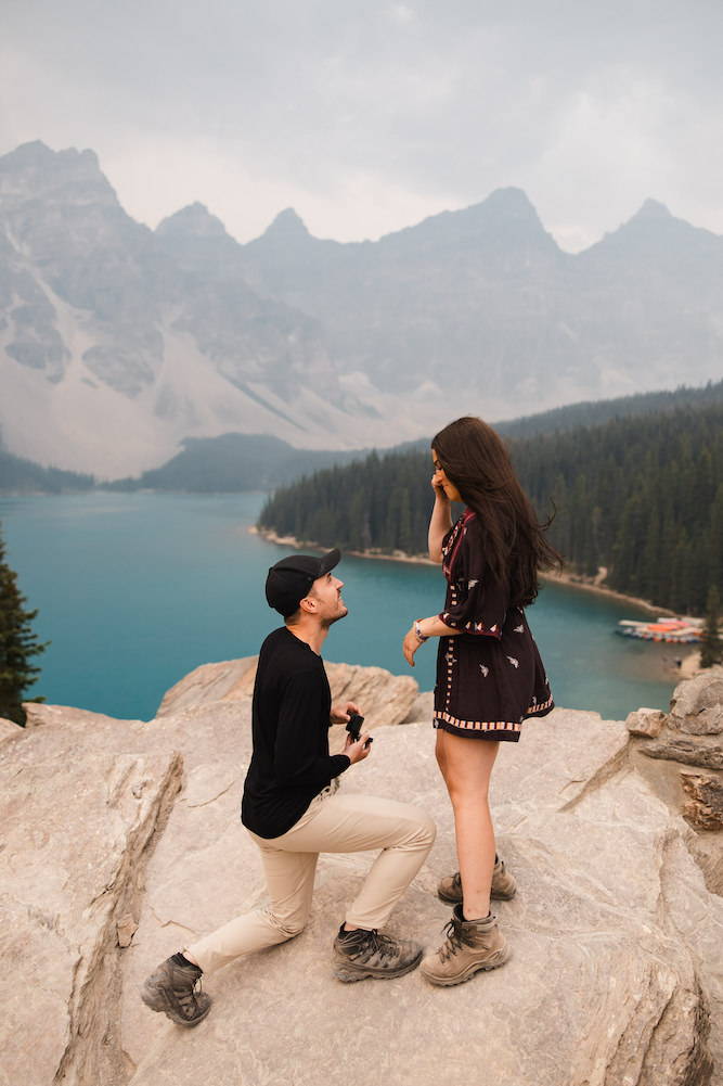 man proposing on one knee moraine lake bbanff