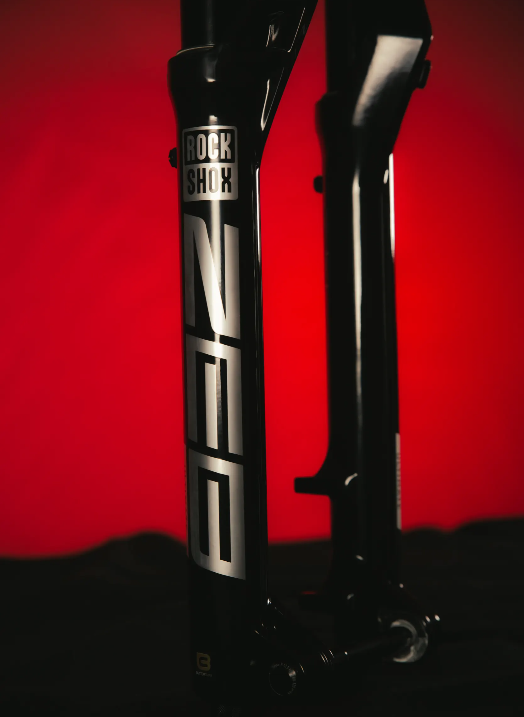 rockshox zeb ultimate mountain bike fork in silver on a red and black background