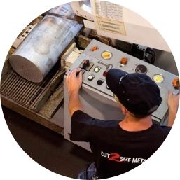 Person operating metal saw on round bar