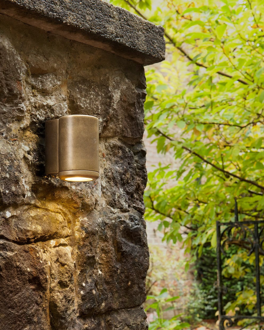 Brass Cylinder Wall Light on an Exterior Stone Wall