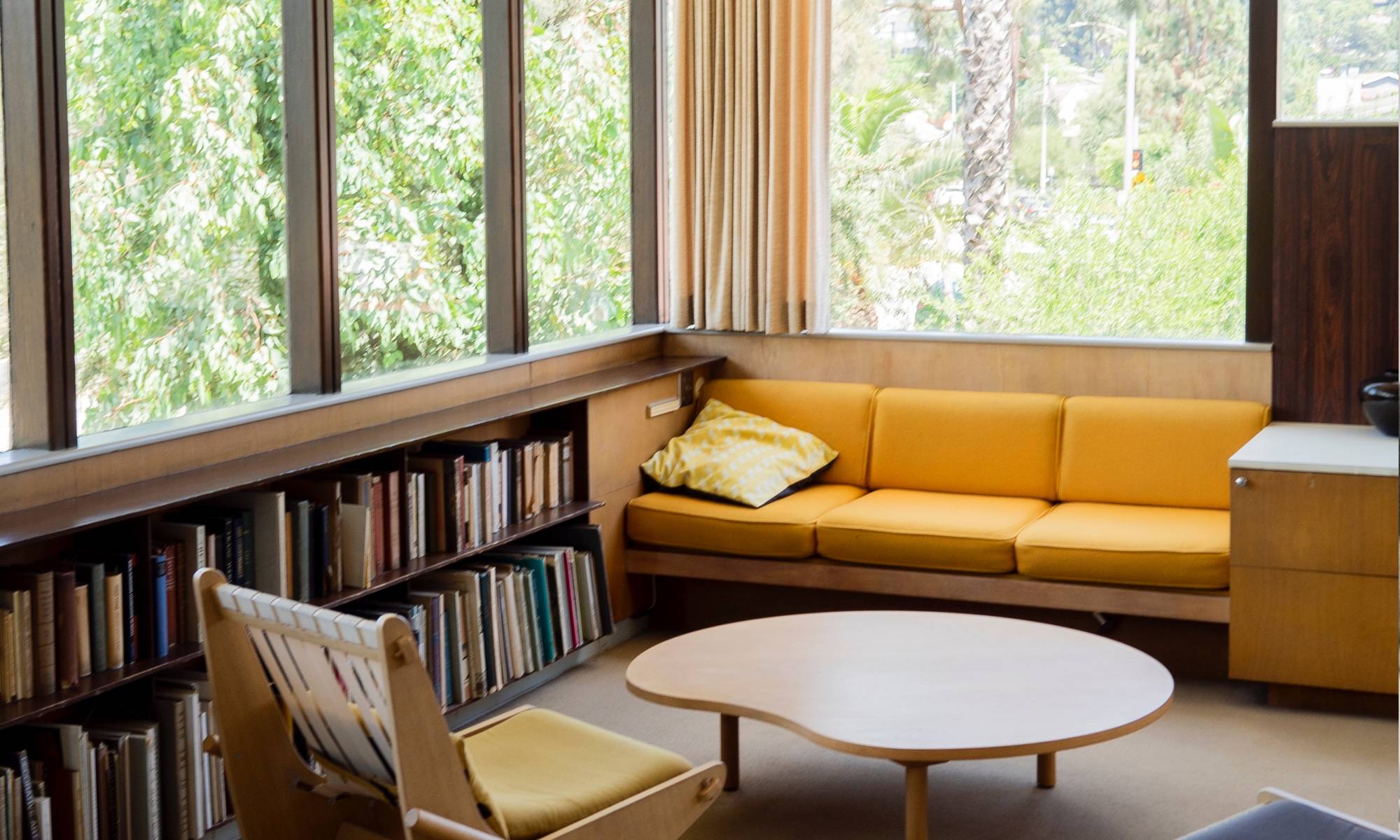 Built-in couch and low bookcases with modernist kidney-shaped coffee table