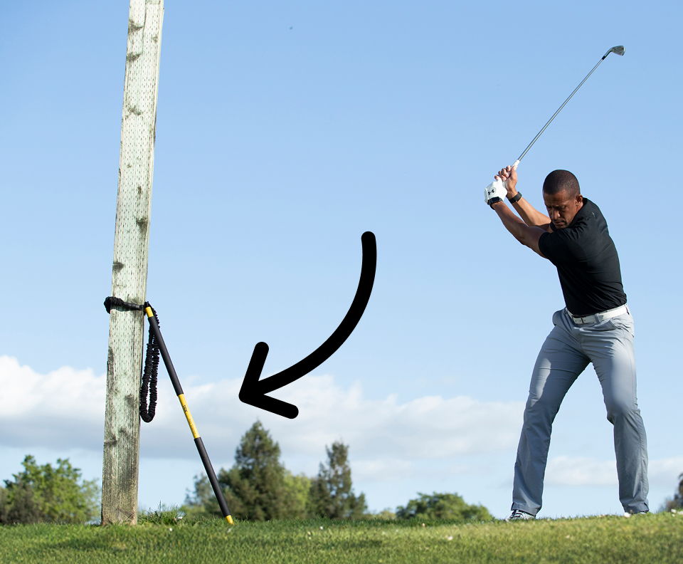 Golfer swinging a golf club with a TRX Rip Trainer in the background