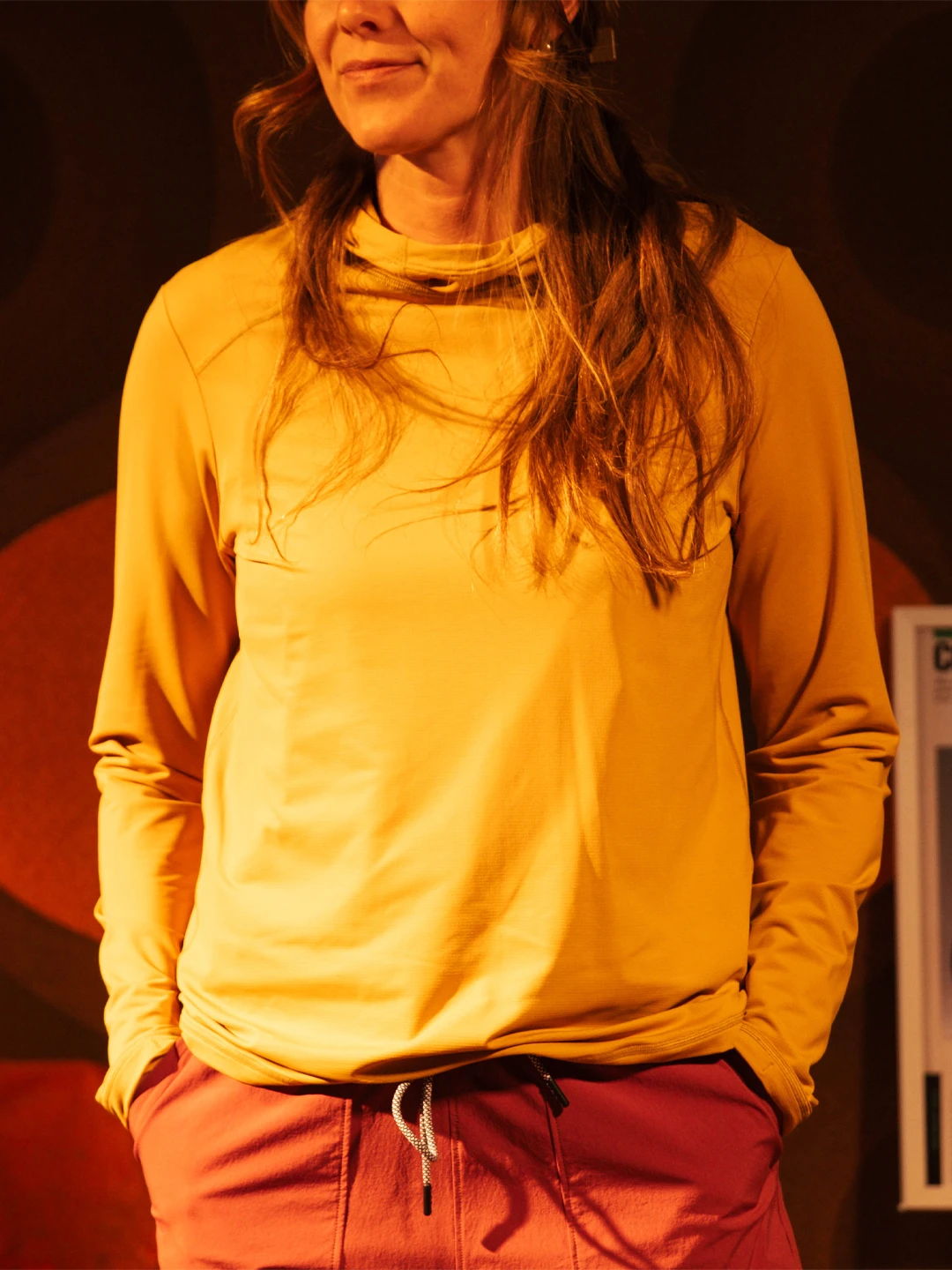 Person wearing a yellow long-sleeve shirt and pink pants.
