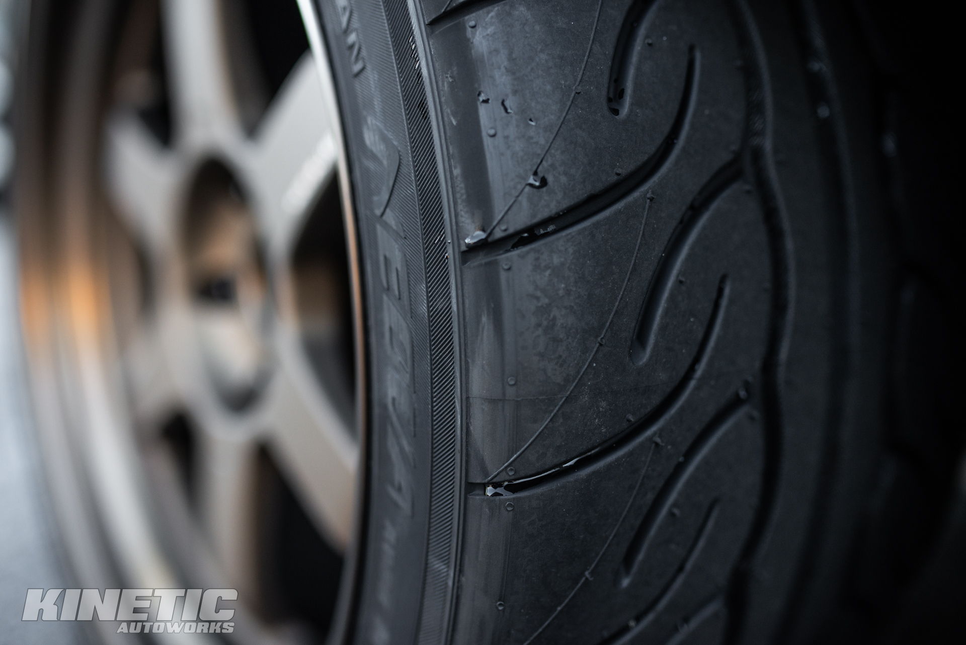Close-up of a performance tire and wheel photographed at Kinetic Autoworks
