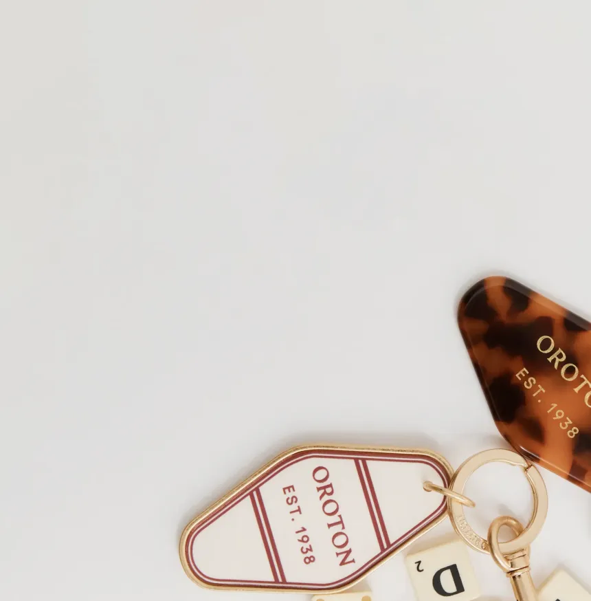 Keychain with tags from the brand Oroton on a white background.