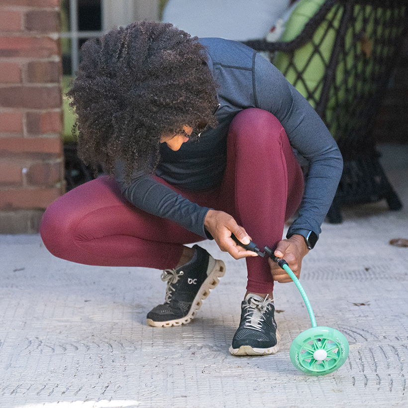 Person in athletic wear adjusting Crossrope SpinJumper on the ground.