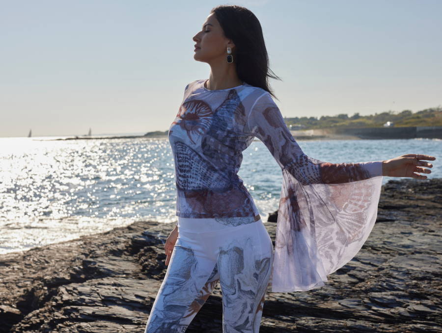 Woman wearing mesh cover up tunic shirt with large sleeves over matching stretch knit tank top and pants in shell print with brown and white by Ala von Auersperg in Newport Rhode Island