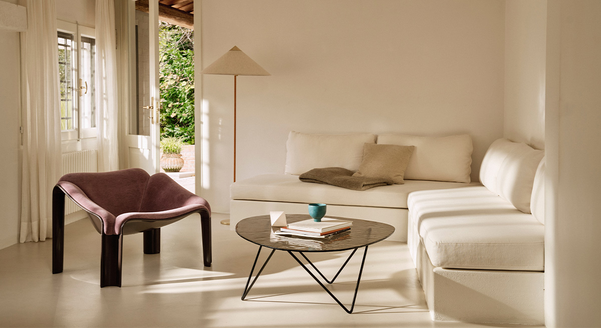 A cozy Gubi living room with a white sofa, purple chair, and coffee table.