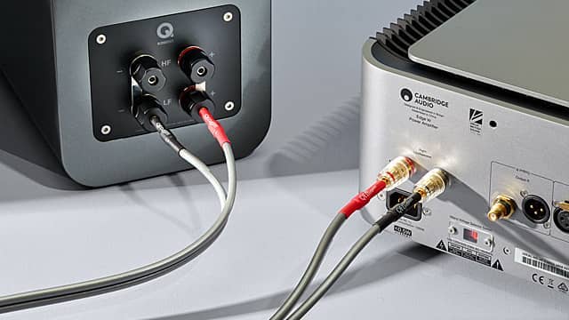 Audio equipment connections with wires plugged into devices.