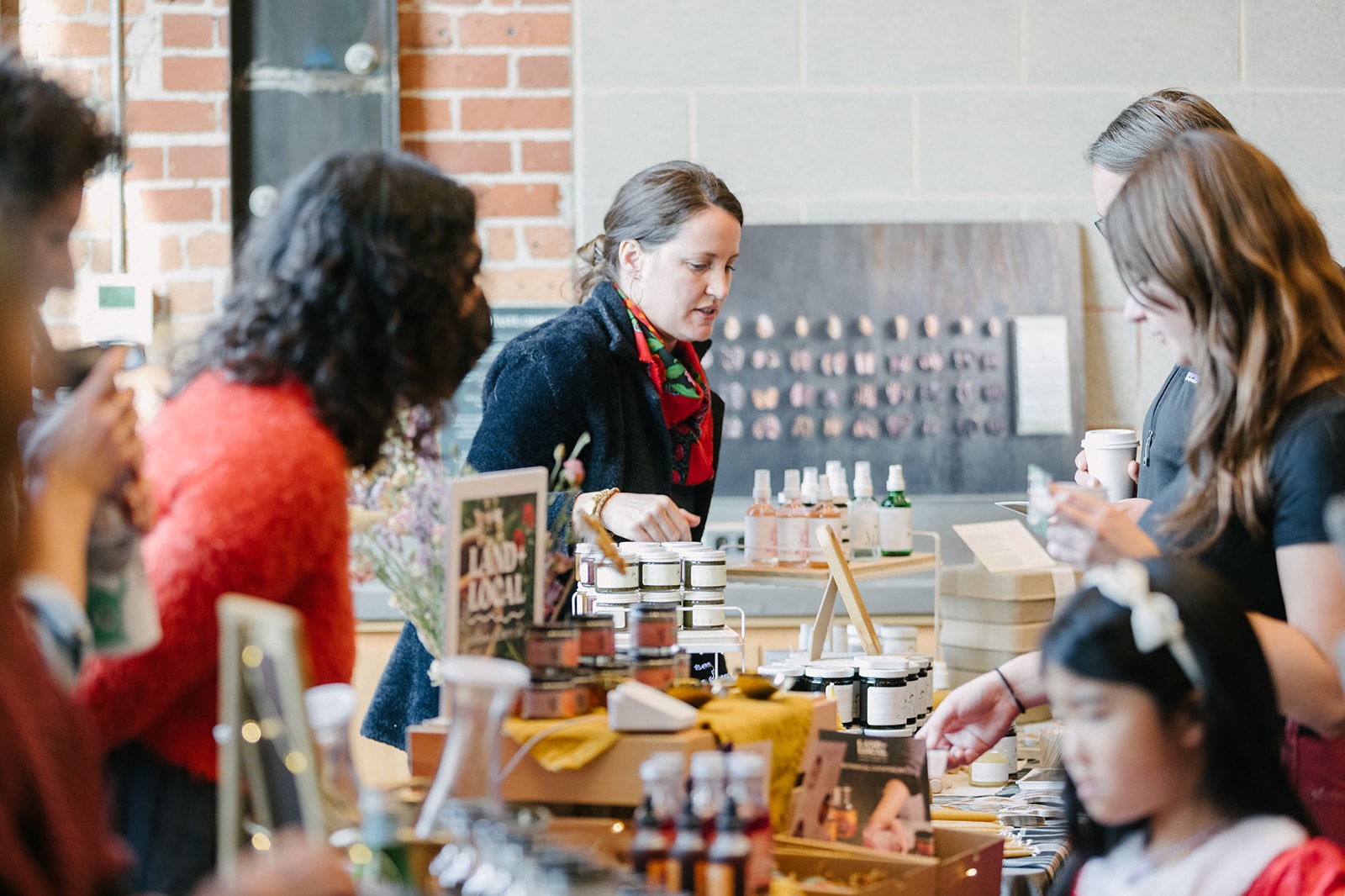 Group of people interacting at a market or food stall.