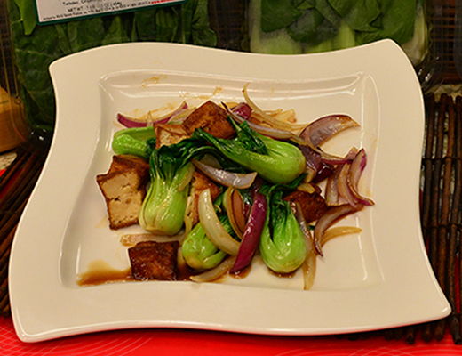 Stir-fried vegetables with tofu on a white plate.